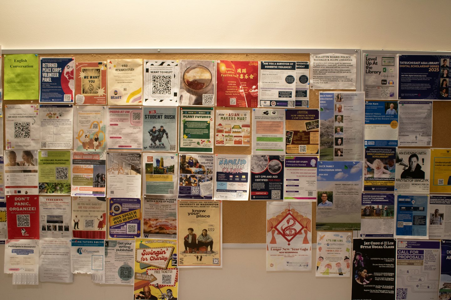 Ein Pinnbrett voller bunter Flyer an einer Universität.
